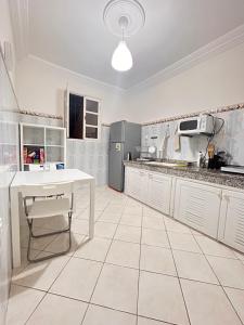 a kitchen with a white table and a white floor at WELKAM Home & Coworking in Essaouira