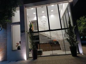 a building with large glass doors and potted plants at Hotel Flores de Holambra in Holambra