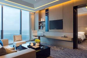 una camera d'albergo con letto e TV di Renaissance Suzhou Wujiang Hotel a Suzhou