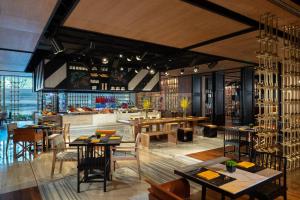 a restaurant with tables and chairs and a bar at Renaissance Hangzhou Northeast in Yuhang