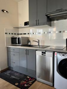 a kitchen with a sink and a microwave at Chic studio Courbevoie Paris in Courbevoie