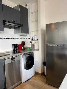 a kitchen with a washing machine and a refrigerator at Chic studio Courbevoie Paris in Courbevoie