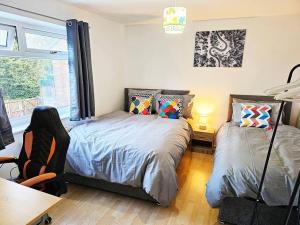 a bedroom with two beds and a desk and a table at Moston, Manchester in Manchester