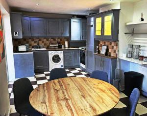 a kitchen with a wooden table and chairs in it at Moston, Manchester in Manchester