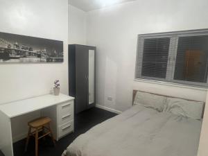 um quarto branco com uma secretária e uma cama em Cosy central apartment near Stokes Croft em Bristol