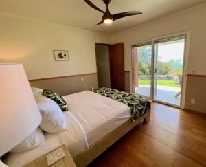 1 dormitorio con 1 cama y ventilador de techo en Mango Sunset Bed and Breakfast, en Kailua-Kona