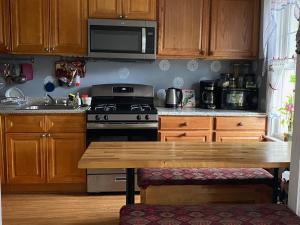eine Küche mit Holzschränken, einem Herd und einem Holztisch in der Unterkunft Classical American House 4 in Brooklyn