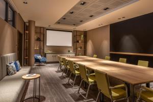 a conference room with a long table and chairs at Courtyard by Marriott Cologne in Cologne