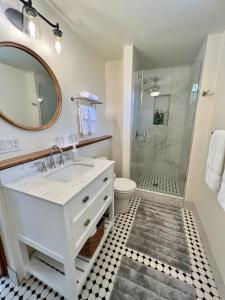 ein Badezimmer mit einem weißen Waschbecken und einer Dusche in der Unterkunft Mango Sunset Bed and Breakfast in Kailua-Kona
