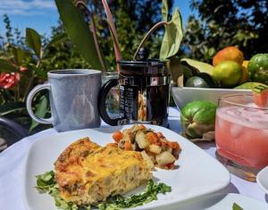 a white plate with a piece of food on a table at Mango Sunset Bed and Breakfast in Kailua-Kona