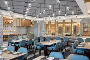 a rendering of a restaurant with tables and chairs at Delta Hotels by Marriott Kunming in Kunming