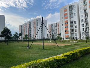 a playground in a park with tall buildings at Hermoso y comodo apartamento con Aire acondicionado y parqueo privado en unidad residencial - Jamundi in Jamundí