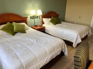 um quarto de hotel com duas camas com almofadas verdes em Great Condo Incredible Location em Orlando