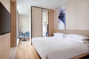 1 dormitorio con 1 cama blanca grande y TV en Fairfield by Marriott Beijing Haidian, en Beijing