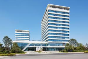 an office building with two tall buildings at Courtyard by Marriott Qinhuangdao West in Qinhuangdao