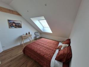 Schlafzimmer mit einem roten Bett und einem Dachfenster in der Unterkunft Appartement avec vue in Fougères