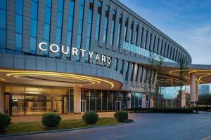 a building with a sign on the side of it at Courtyard by Marriott Yinchuan in Yinchuan