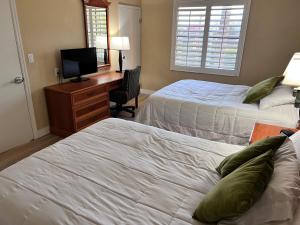 um quarto com 2 camas e uma secretária com uma televisão em Great Condo Incredible Location em Orlando