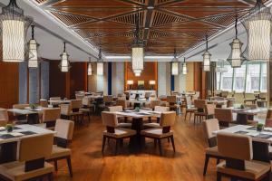 a dining room with tables and chairs and chandeliers at Courtyard by Marriott Yinchuan in Yinchuan