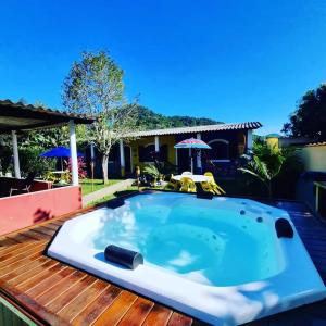 a jacuzzi tub sitting on top of a wooden deck at Pousada_tres_amores in Itariri