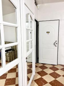 Habitación con puerta blanca y suelo a cuadros en Appartement Bab Lamrissa, en Sale