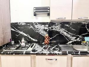 una cocina con encimera de mármol negro en Appartement Bab Lamrissa, en Sale
