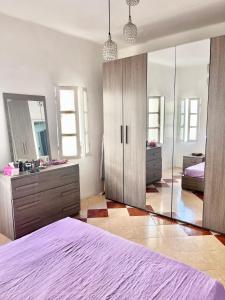 1 dormitorio con cama y espejo grande en Appartement Bab Lamrissa, en Sale
