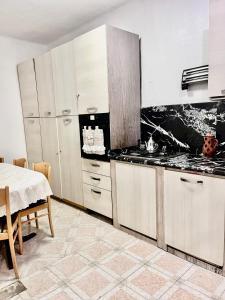 cocina con armarios blancos, mesa, mesa y mesa en Appartement Bab Lamrissa, en Sale