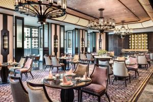 a restaurant with tables and chairs and chandeliers at Le Meridien Zhongshan in Zhongshan