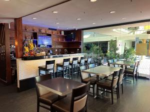 a restaurant with tables and chairs and a bar at Best Western Hollywood Plaza Inn Hotel - Hollywood Walk of Fame LA in Los Angeles