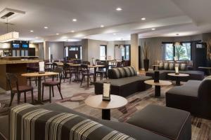 a hotel lobby with couches and tables and a bar at Courtyard Milpitas Silicon Valley in Milpitas