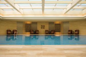 a large swimming pool with chairs in a building at Courtyard By Marriott Shanghai Xujiahui in Shanghai