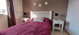 um quarto com uma cama com lençóis roxos e duas mesas de cabeceira em Casa Pascal, Bº Villa Belgrano em Córdova