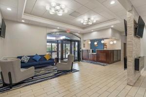 a lobby with a couch and chairs and a kitchen at Comfort Inn & Suites Mundelein-Vernon Hills in Mundelein