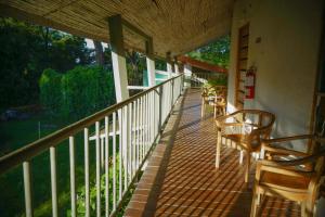 Un balcón con sillas y mesas en una casa en Hotel Sol Sámara, en Sámara
