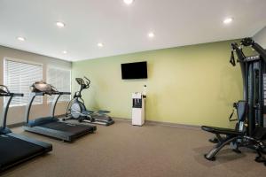 un gimnasio con máquinas de correr y TV de pantalla plana en WoodSpring Suites Moreno Valley, en Moreno Valley