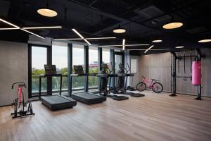 um ginásio com bicicletas e equipamento de exercício numa sala em Moxy Shanghai Hongqiao NECC em Xangai