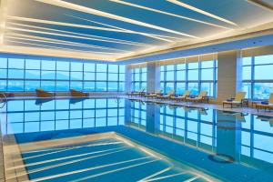 a swimming pool in a building with windows at The Westin Nanjing Xuanwu Lake in Nanjing