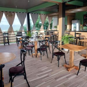 a restaurant with wooden tables and chairs and windows at Vee's Apartments SLU in Castries