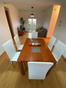 comedor con mesa de madera y sillas blancas en APARTAMENTO GOR en Granada