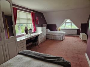 a bedroom with two beds and a desk and a window at Mountain view kingscourt 
