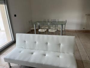 ペスカーラにあるAppartamento Pescara Sudの白いソファ、テーブル、椅子が備わる客室です。