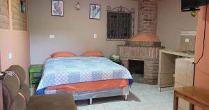 a bedroom with a bed and a fireplace at HOSTAL CABAÑAS AVE MARIA in Concepción de Ataco