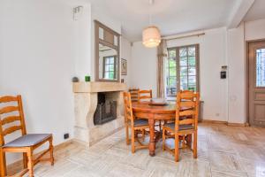a dining room with a table and chairs and a fireplace at Villa Victor Hugo in Deauville