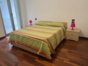 een slaapkamer met een bed en een nachtkastje met een lamp bij Appartamento Pescara Sud in Pescara
