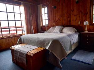 a bedroom with a bed in a room with windows at Cabañas Los Bajos in Frutillar