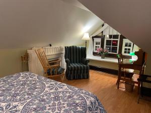 a bedroom with a bed and a chair and a window at Prince County Guest House in Miscouche