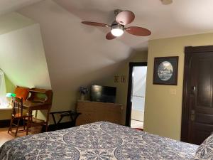 a bedroom with a bed and a ceiling fan at Prince County Guest House in Miscouche