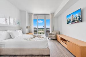 biała sypialnia z łóżkiem i oknem w obiekcie Modern 2 bed at Beach Walk 17th floor Miami w mieście Hollywood