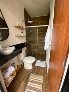 a bathroom with a toilet and a glass shower at Casa Conchas do Patacho in Pôrto de Pedras